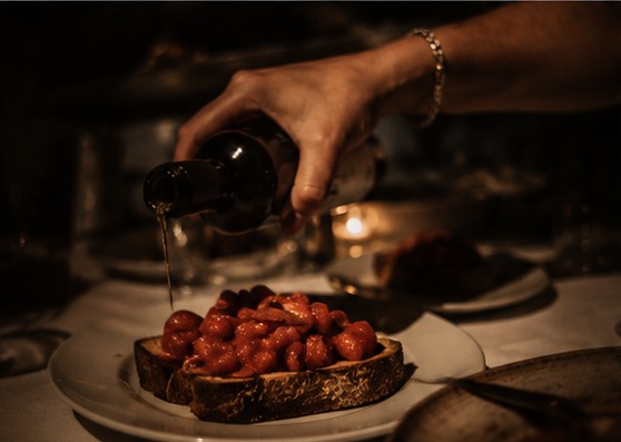 Olivenöl wird über frische Bruschetta mit Kirschtomaten gegossen