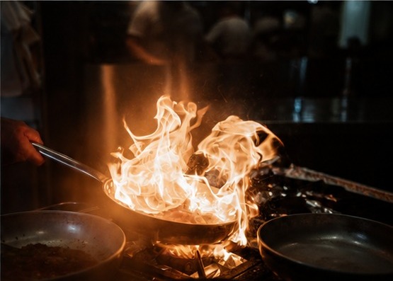 Pfanne mit Flammen in der offenen Küche