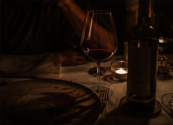 Glas Rotwein bei warmem Kerzenlicht