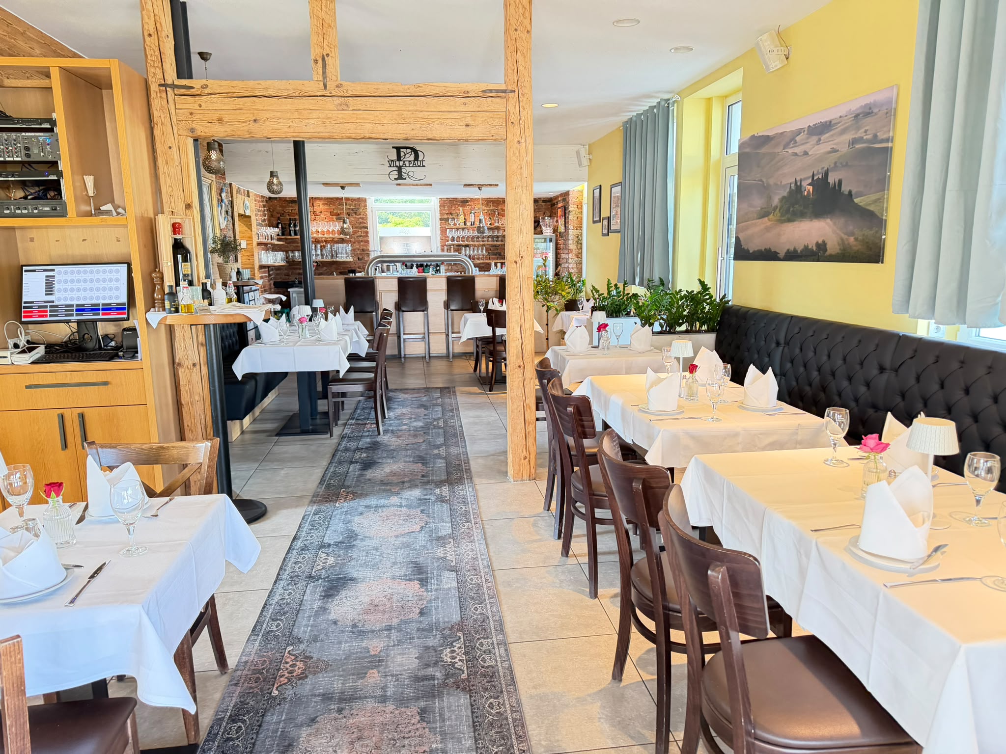 Gastraum des Villa Paul mit eingedeckten Tischen und Bar