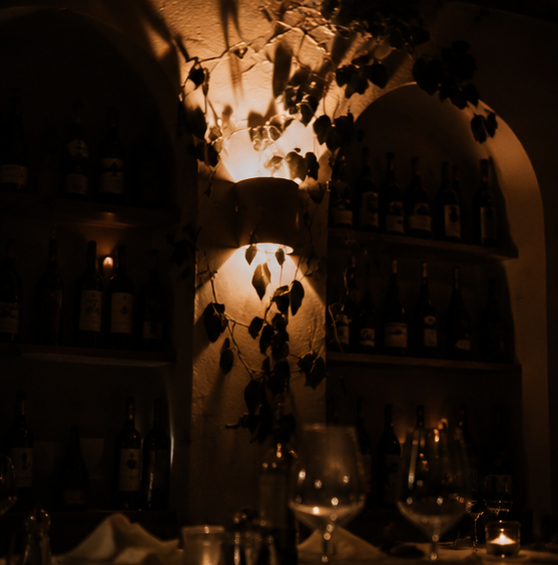 Stille Restaurant-Atmosphäre mit Weinregalen und Kerzenlicht